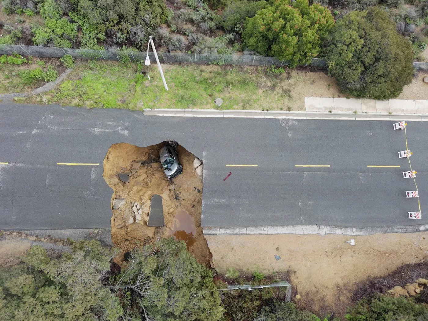 This aerial view captured on 10 January 2023, shows two cars swallowed by a large sinkhole that formed in the Chatsworth neighborhood of Los Angeles, California, during a day of relentless rain. Storms caused widespread flooding in the state since the end of 2022. Photo: Robyn Beck / AFP / Getty Images