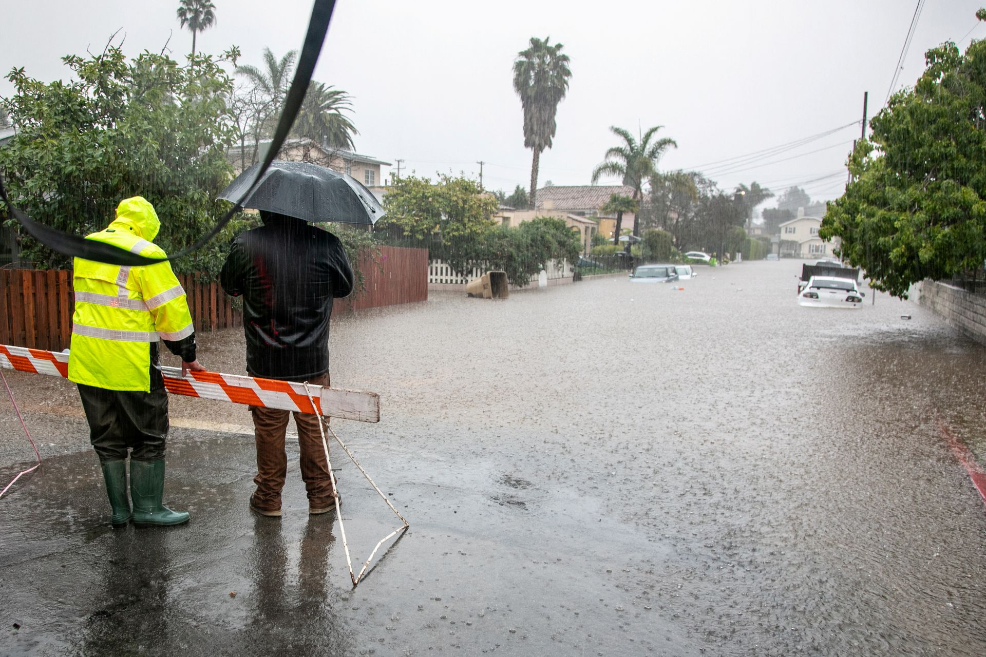 Residents look at abandoned cars on a flooded street in east Santa Barbara, California, U.S. 9 January 2023. Photo: Erica Urech / REUTERS