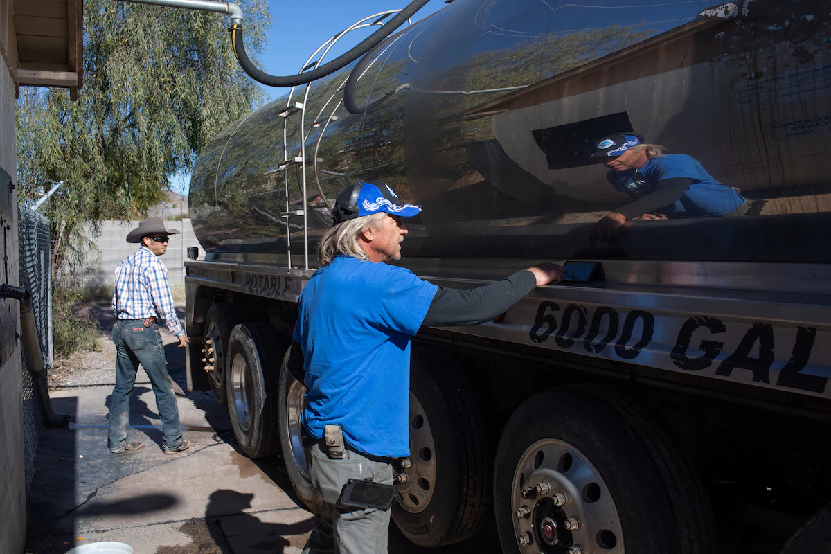 John Hornewer sets alarms on his phone in two-minute intervals, after which he puts a quarter in the fill station, as he fills up his 6,000-gallon tanker to haul water from Apache Junction to Rio Verde Foothills. Photo: Caitlin O'Hara / The Washington Post