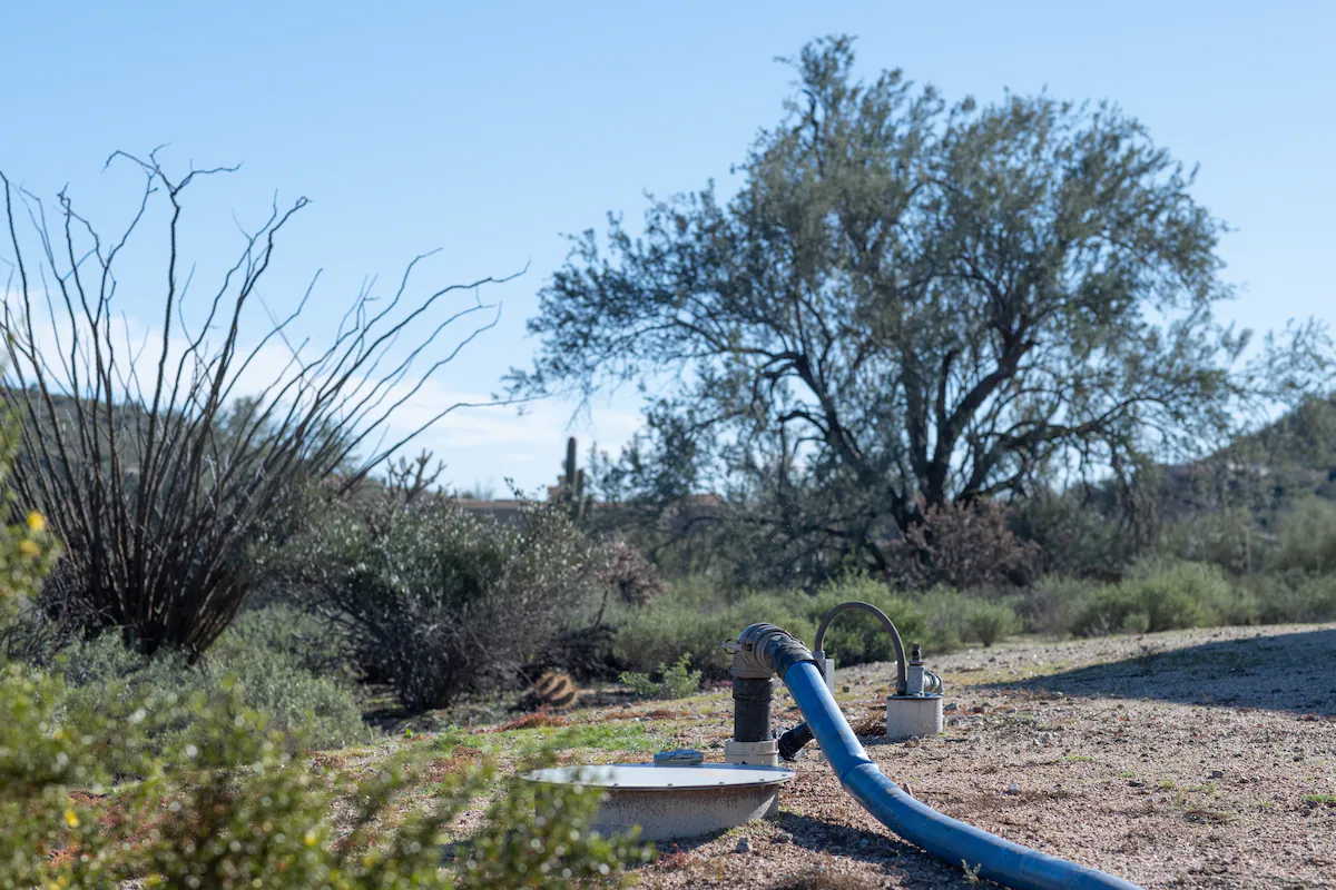 A hose from John Hornewer’s tanker fills up Britney Kellum’s in-ground water tank in a home she’s renting in Rio Verde Foothills. Photo: Caitlin O'Hara / The Washington Post