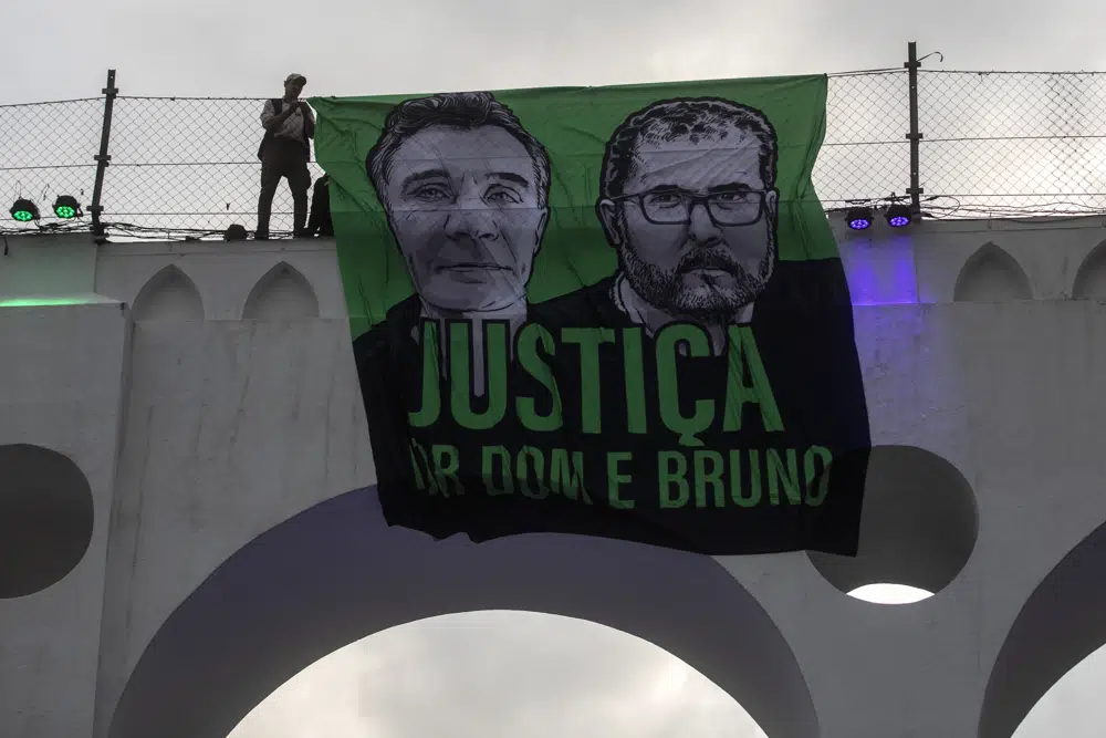 A sign that reads in Portuguese “Justice for Dom and Bruno” and with images of the British journalist Dom Phillips, on the left, and the indigenous specialist Bruno Pereira is displayed on the Arcos da Lapa aqueduct during a protest by environmental groups in Rio de Janeiro, Brazil, 26 June 2022. Brazilian police said Monday, 23 January 2023, they planned to indict Ruben Dario da Silva Villar, a Colombian fish trader, as the mastermind of the murders. Photo: Bruna Prado / AP Photo