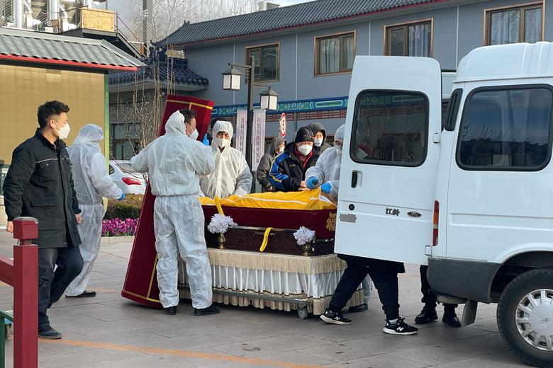 Workers in protective suits transfer a body in a casket at a funeral home, amid the coronavirus disease (COVID-19) outbreak in Beijing, China, 17 December 2022. Photo: Alessandro Diviggiano / REUTERS