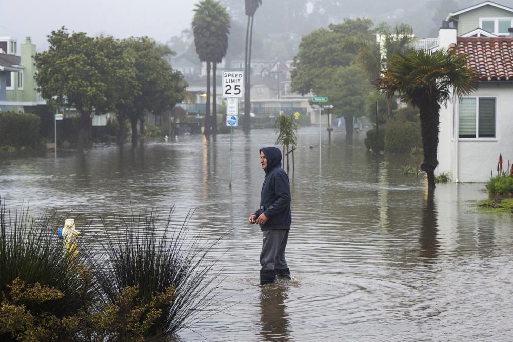 A man wades through a flooded street in the Rio Del Mar neighborhood of Aptos, California, Monday, 9 January 2023. Photo: Nic Coury / AP Photo