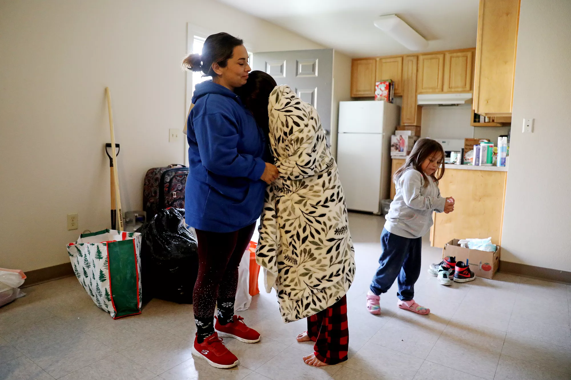 Erica Lopez Bedolla, left, with daughters Miley Lopez, 10, center, and Leanie Lopez, 4, at their temporary housing. The Lopez family had to evacuate to temporary shelter at Felix Torres Housing after their home was severely flooded from a storm in Planada, California in January 2023. Photo: Gary Coronado / Los Angeles Times