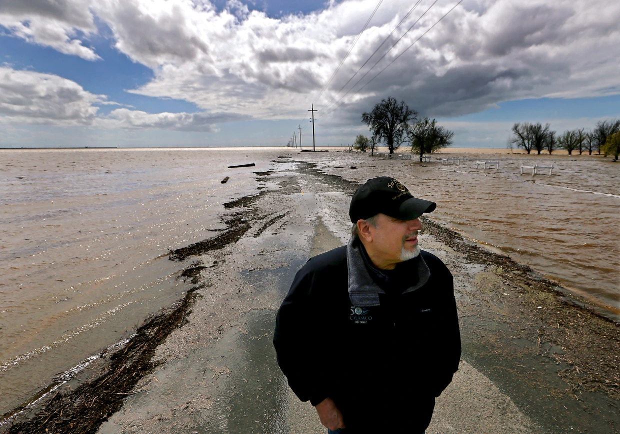 Mark Grewel on a farm road that was flooded in Lemoore, Califoria, 21 March 2023. Photo: Luis Sinco / Los Angeles Times / Getty Images