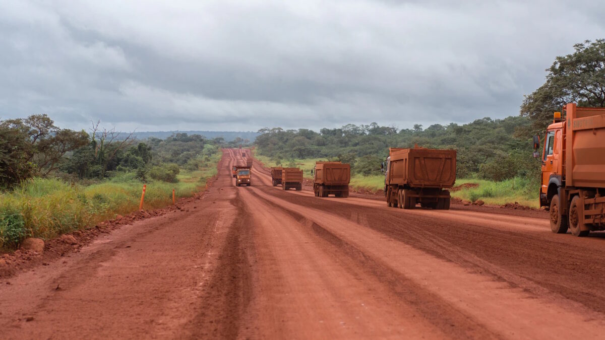Trucks transport bauxite on a red-dirt mining road in the Boké region of Guinea. Photo: Chloe Sharrock / MYOP / The Washington Post