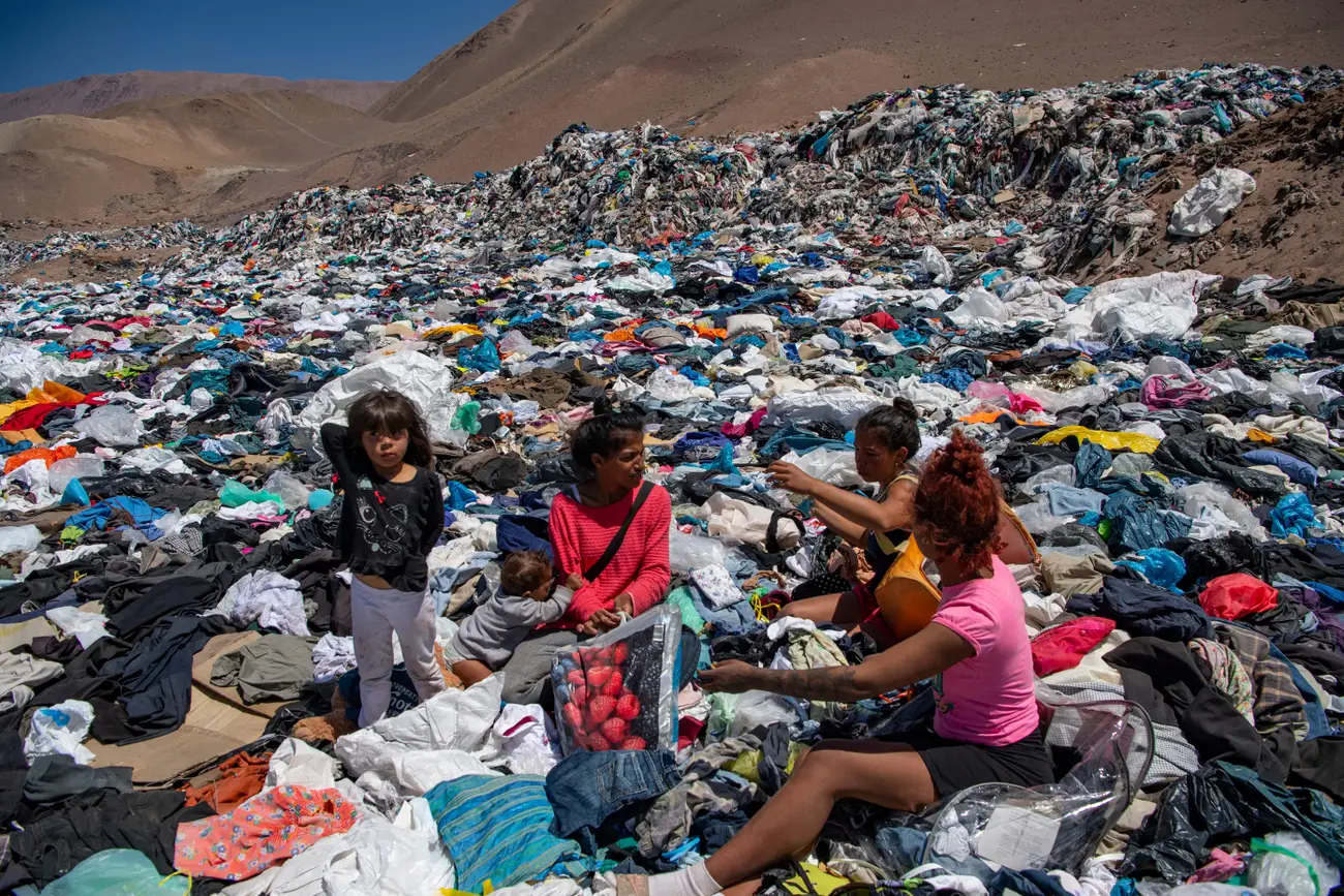 Women search for clothing items in a huge clothing dump in the Atacama Desert. Photo: Martin Bernetti / AFP / Getty Image