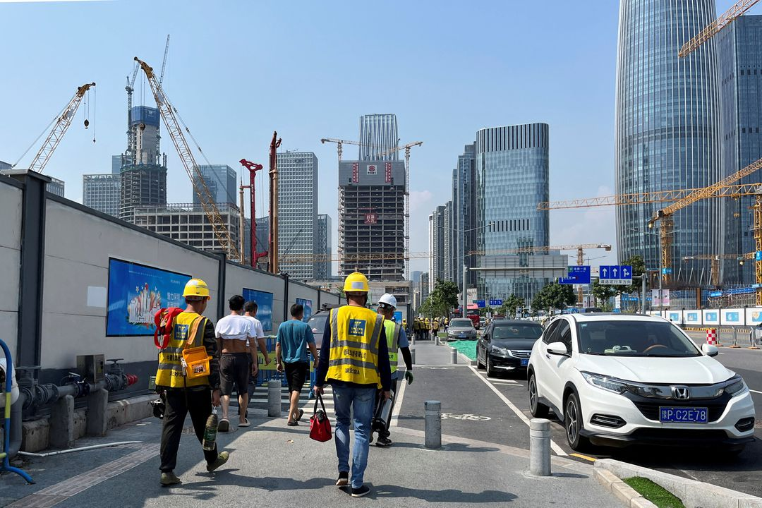Construction workers walk in the sun amid a yellow alert for heatwave in Shenzhen, Guangdong province, China, 2 June 2023. Photo: David Kirton / REUTERS