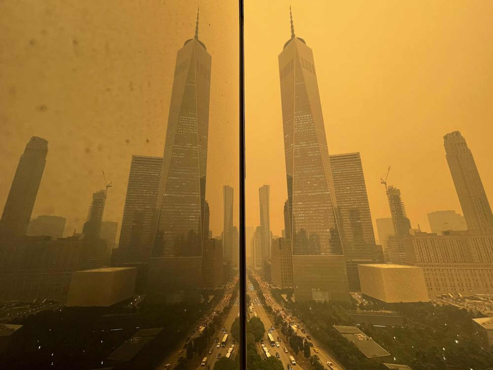 Traffic moves along West Street past One World Trade Center, in this mirror image reflected in the facade of a building, Wednesday, 7 June 2023, in New York, amidst smokey haze from wildfires in Canada. Smoke from Canadian wildfires poured into the U.S. East Coast and Midwest on Wednesday, covering the capitals of both nations in an unhealthy haze, holding up flights at major airports and prompting people to fish out pandemic-era face masks. Photo: Andy Bao / AP Photo