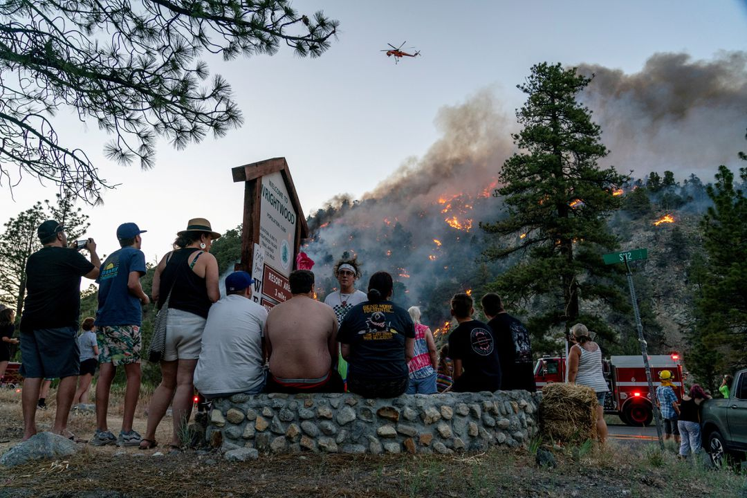 Residents watch part of the Sheep Fire wildfire burn through a forest on a hillside near their homes in Wrightwood, California. 11 June 2022. Photo: Kyle Grillot / REUTERS