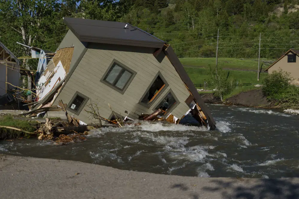 A house sits in Rock Creek after floodwaters washed away a road and a bridge in Red Lodge, Montana, 15 June 2022. Photo: David Goldman / AP Photo