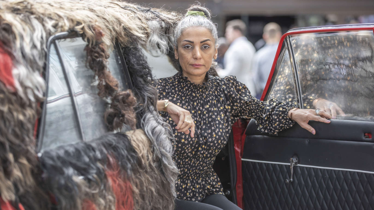 Iranian-Canadian artist Simin Keramati sits in the PaykanArtCar during its unveiling at the Oslo Freedom Forum on 13 June 2023. The car is adorned with women's hair, serving as a visual representation of support for the “Women, Life, Freedom” protest movement against Iran’s Islamist regime. Photo: Fredrik Naumann / AP Images / PaykanArtCar