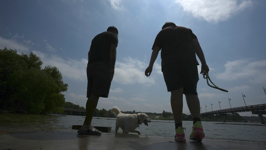 Brothers Fernando, left, and Jacob Ortega watch their dogs during a heatwave at White Rock Lake in Dallas, Tuesday, 20 June 2023. Photo: LM Otero / AP Photo