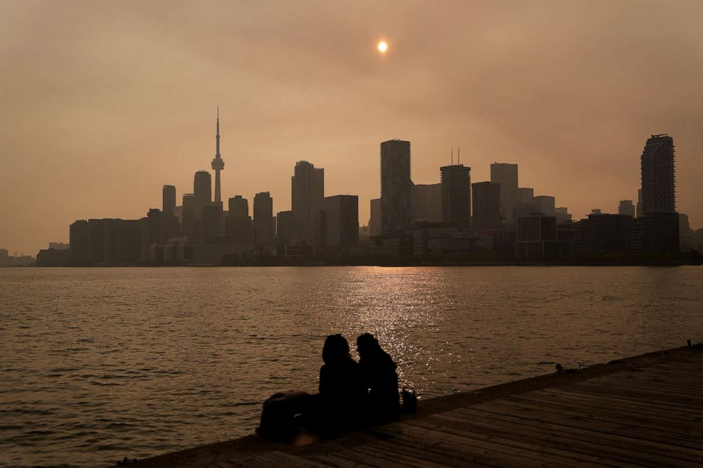 People watch the sunset as the smoke from wildfires is visible in Toronto on 28 June 2023. Photo: Chris Young / AP