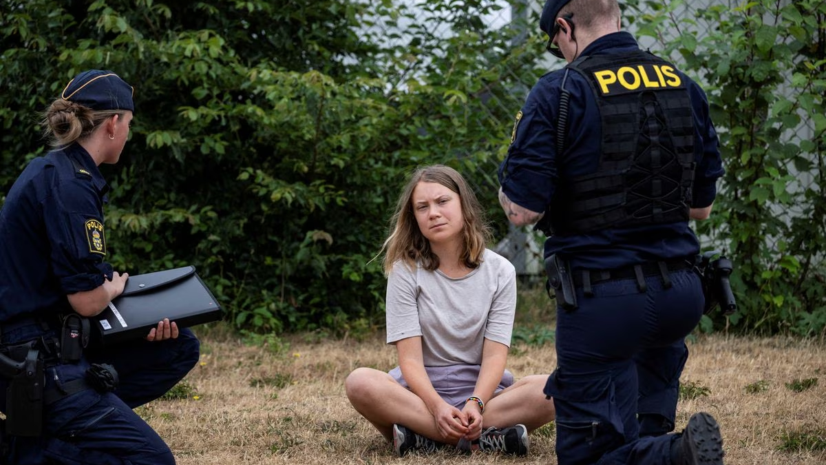 Police talk to Greta Thunberg as they move climate activists from the organization Ta Tillbaka Framtiden, who are blocking the entrance to Oljehamnen in Malmo, Sweden, 19 June 2023. Photo: Johan Nilsson / TT News Agency / REUTERS