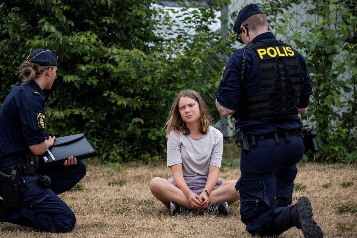 Police talk to Greta Thunberg as they move climate activists from the organization Ta Tillbaka Framtiden, who are blocking the entrance to Oljehamnen in Malmo, Sweden, 19 June 2023. Photo: Johan Nilsson / TT News Agency / REUTERS