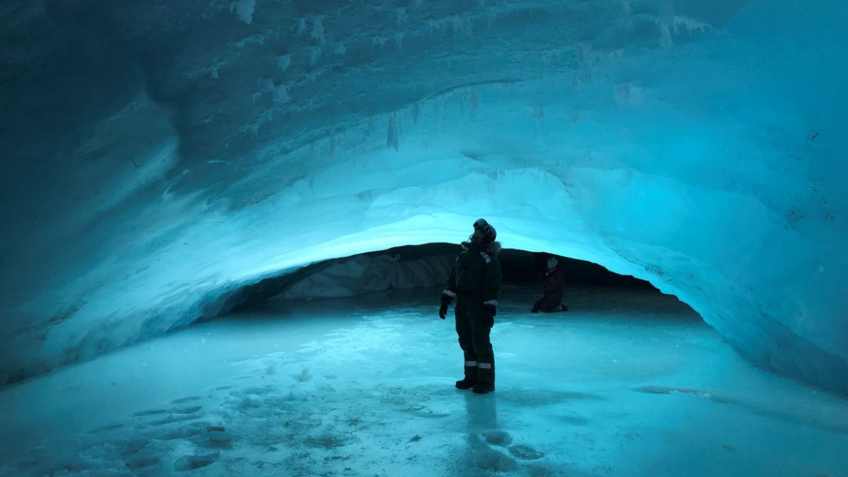 A researcher stands in a glacier cave on Svalbard, Norway. In 2023, scientists discovered that as the Arctic warms, shrinking glaciers are exposing bubbling groundwater springs which could provide an underestimated source of the potent greenhouse gas methane. Photo: Gabrielle Kleber