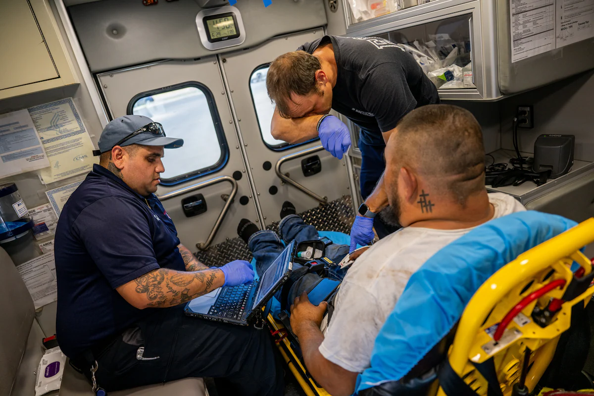 Emergency medical technicians William Dorsey and Omar Amezcua assist a person who had reported chest pains after working outside for hours on 29 June 2023 in Eagle Pass, Texas. Photo: Brandon Bell / Getty Images