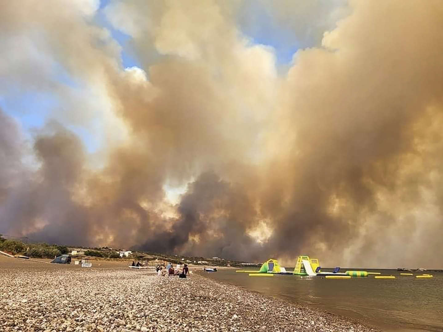 Clouds of smoke from a forest fire rise to the sky on the island of Rhodes, Greece, Saturday, 22 July 2023. A large blaze burning on the Greek island of Rhodes for the fifth day forced authorities to order an evacuation of four locations, including two seaside resorts. Photo: Rhodes.Rodos / AP