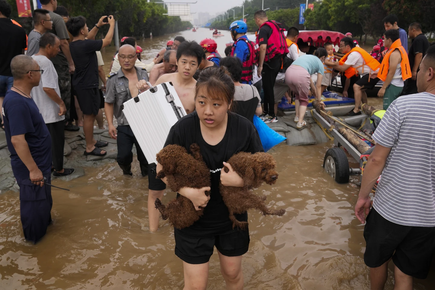A woman carries her pet dogs as residents are evacuated on rubber boats through floodwaters in Zhuozhou in northern China’s Hebei province, south of Beijing, Wednesday, 2 August 2023. Severe floods in China’s northern province of Hebei brought by remnants of Typhoon Doksuri this month killed at least 29 people and caused billions of dollars in economic losses, its provincial government said Friday, 11 August 2023. Photo: Andy Wong / AP Photo