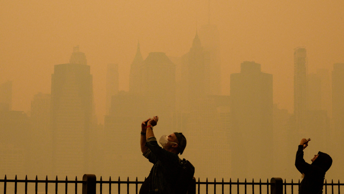 People take photos of the sun as smoke from the wildfires in Canada cause hazy conditions in New York City in June 2023. Photo: Getty Images
