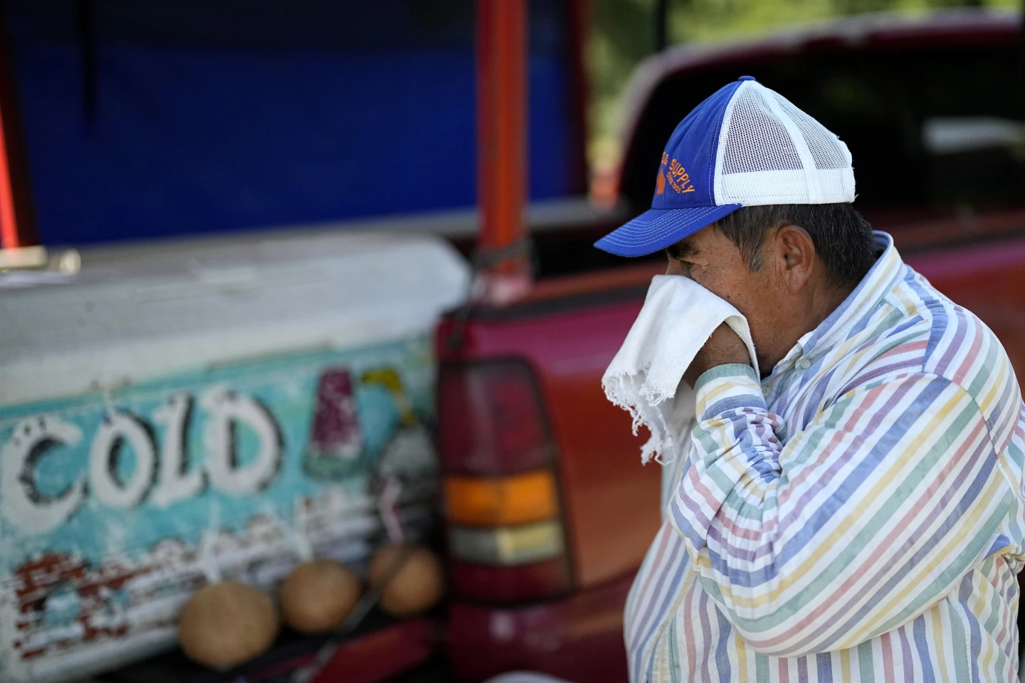 Andres Matamoros wipes the sweat from his face while selling fresh fruit and cold coconuts from his roadside stand Wednesday, 28 June 2023, in Houston. Photo: David J. Phillip / AP Photo