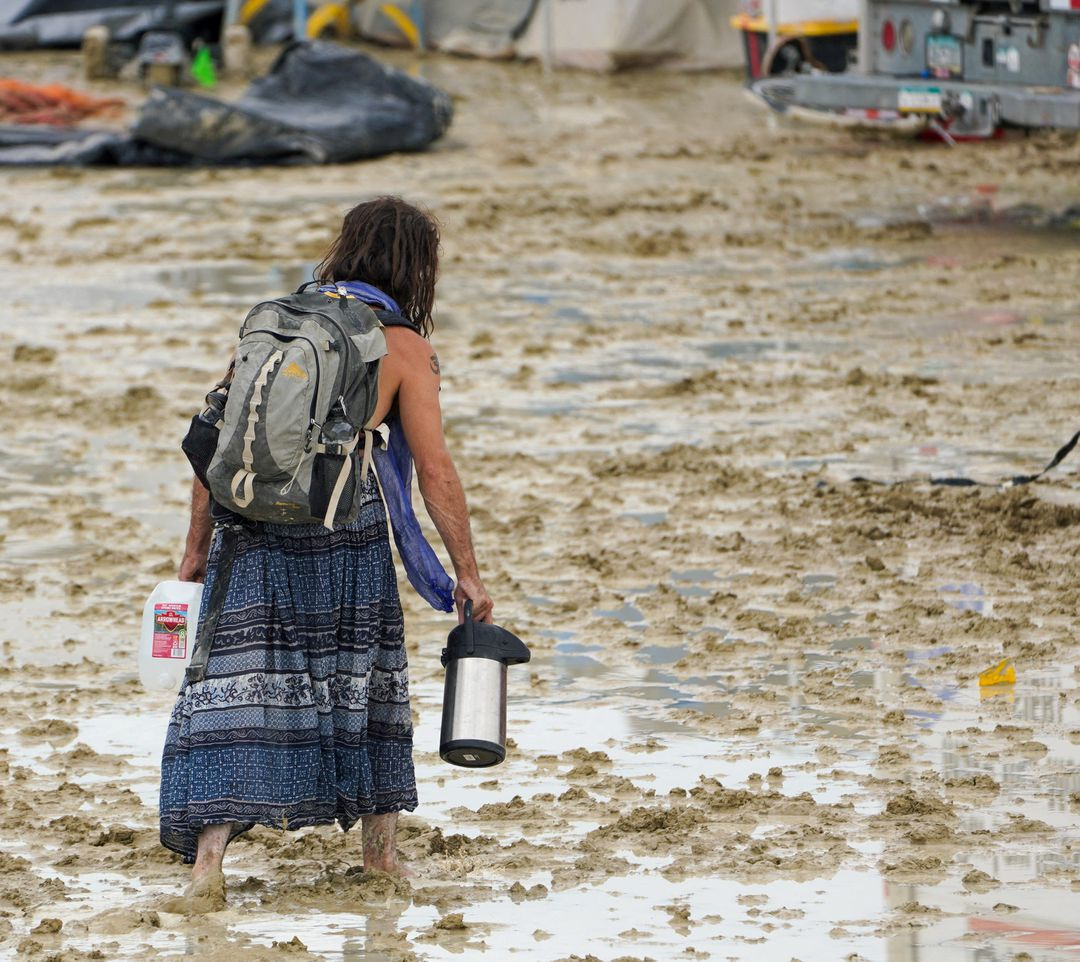 A Burning Man participant trudges through the mud in Black Rock City, in the Nevada desert, after a rainstorm flooded the site and stranded thousands, 2 September 2023. Photo: Trevor Hughes / USA TODAY