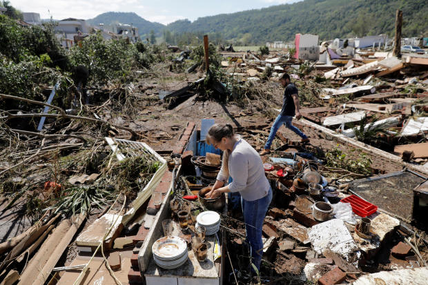 Residents Silvana Primel and Jose Gabriel pick up objects amid the ruins of their home after an extratropical cyclone struck, in Mucum, Rio Grande do Sul state, Brazil, 6 September 2023. Photo: Diego Vara / REUTERS