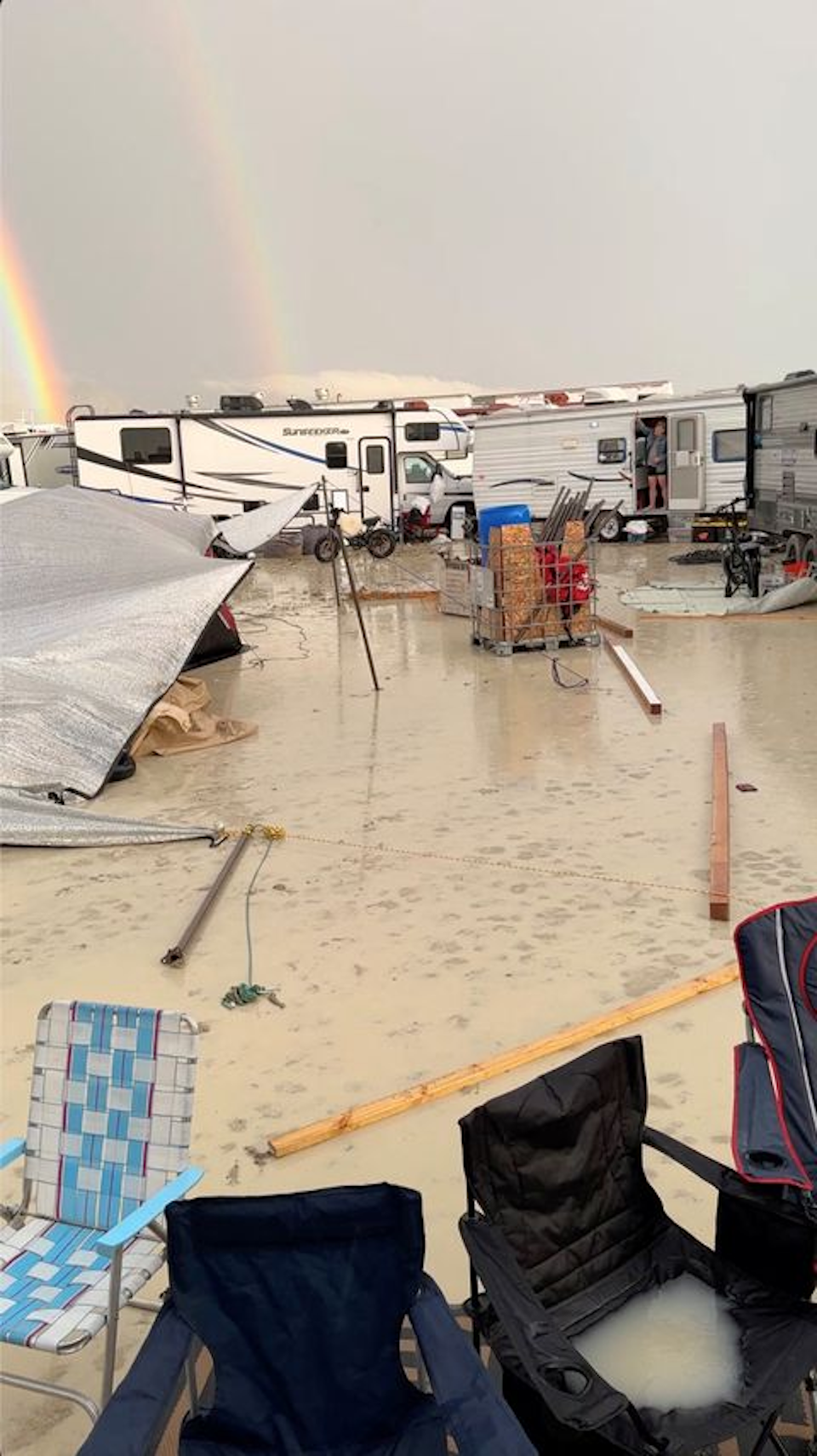 Mud covers the ground at the site of the Burning Man festival in Black Rock, Nevada, U.S., on 1 September 2023, in this screen grab obtained from a social media video. A double rainbow appears in the background against the rainy sky. Photo: Paul Reder / REUTERS