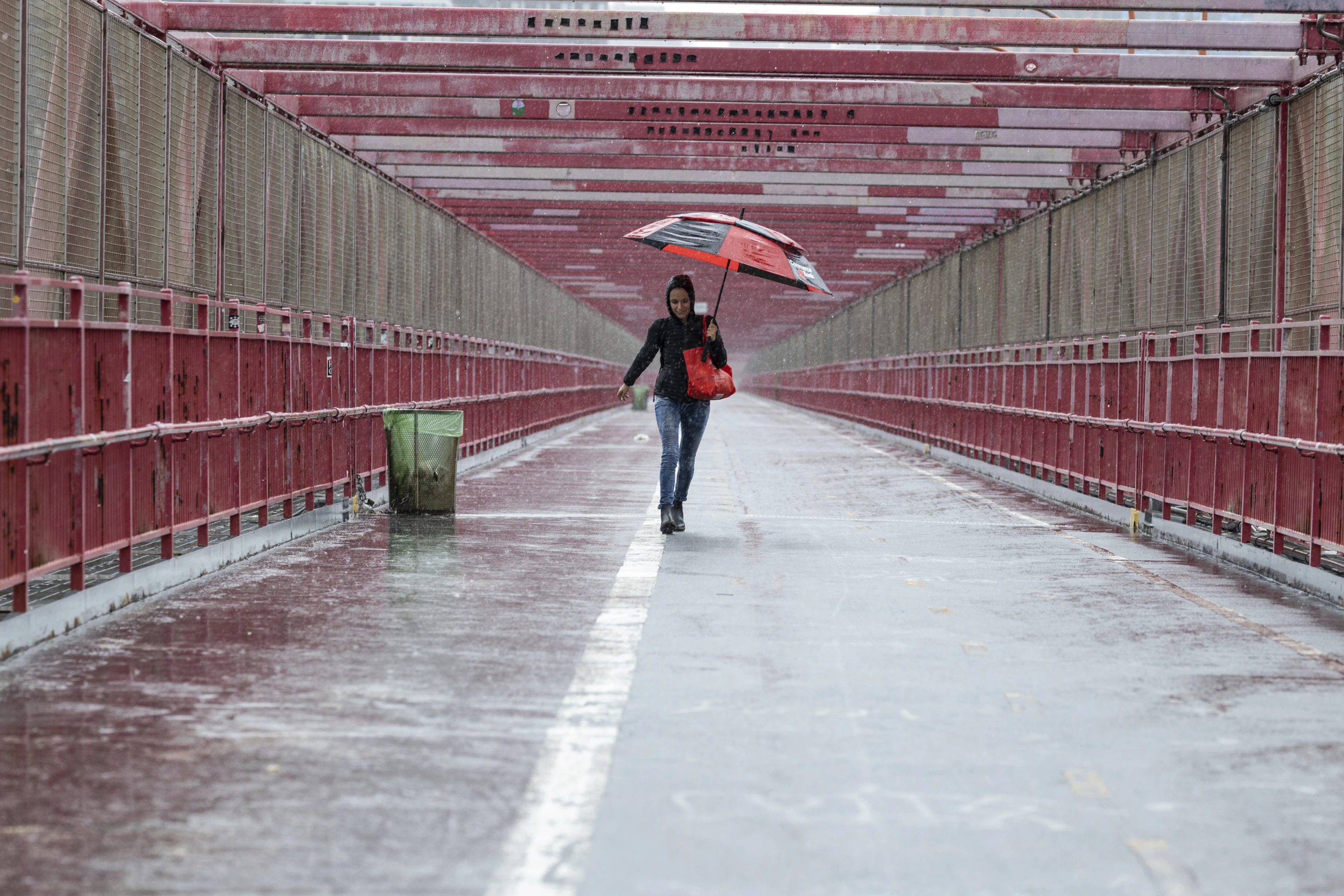 A person walks over the Williamsburg Bridge with an umbrella on Friday, 29 September 2023 in New York. A potent rush-hour rainstorm swamped the New York metropolitan area on Friday, shutting down some subways and commuter railroads, flooding streets and highways, and delaying flights into LaGuardia Airport. Photo: Stefan Jeremiah / AP Photo