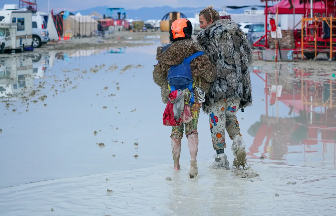 “Dub Kitty” and “Ben Joos”, of Idaho and Nevada, respectively, walk through the mud at the flooded Burning Man festival on 2 September 2023, after a night of dancing with friends. Like many attendees, the two adopted playa names they are known by all week, and declined to give the names they use in the “default world”. Photo: Trevor Hughes / USA TODAY