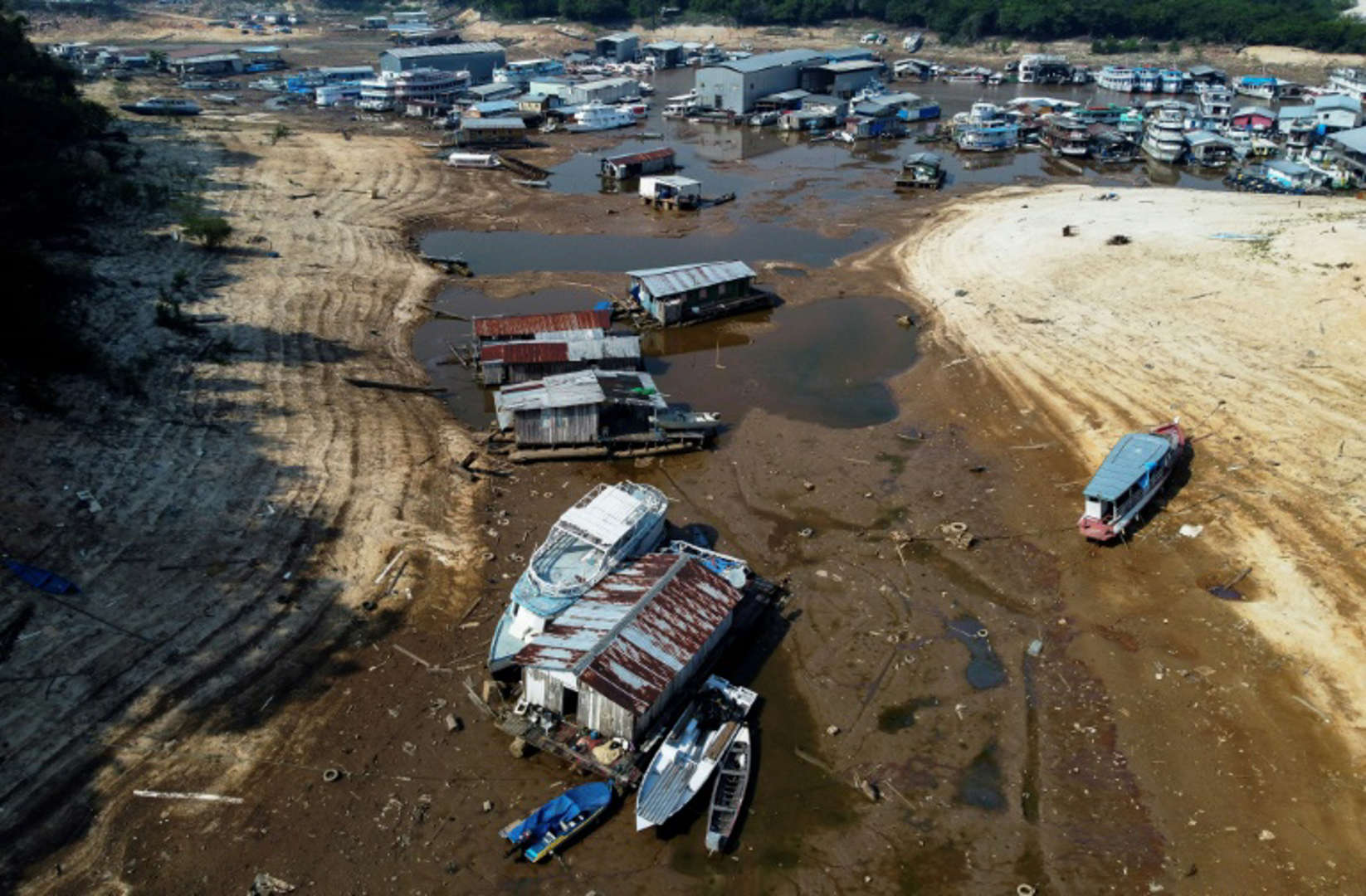 Aerial view of boats stranded in the mud of the parched Rio Negro amid a drought in the Amazonas state of Brazil on 29 September 2023. Photo: Michael Dantas / AFP