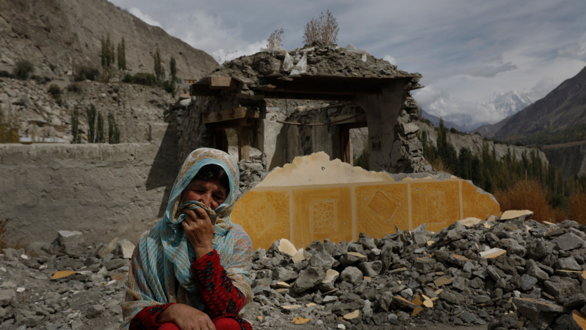 Dilshad Bano, 51, sits on the floor near her house which was damaged after a Glacial Lake Outburst Flooding (GLOF) incident, in Hassanabad village, Pakistan, 9 October 2023 Photo: Akhtar Soomro / REUTERS
