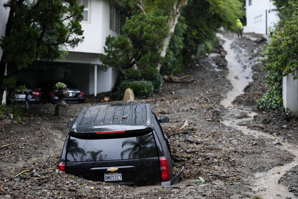 An SUV sits buried by a mudslide, Monday, 5 February 2024, in the Beverly Crest area of Los Angeles. A storm of historic proportions unleashed record levels of rain over parts of Los Angeles on Monday, endangering the city’s large homeless population, sending mud and boulders down hillsides dotted with multimillion-dollar homes and knocking out power for more than a million people in California. Photo: Marcio Jose Sanchez / AP Photo