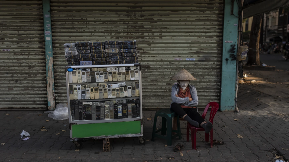 A vendor selling used remote controls for various home appliances takes a nap in Nhat Tao market, the largest informal recycling market in Ho Chi Minh City, Vietnam, Sunday, 28 January 2024. Photo: Jae C. Hong / AP Photo