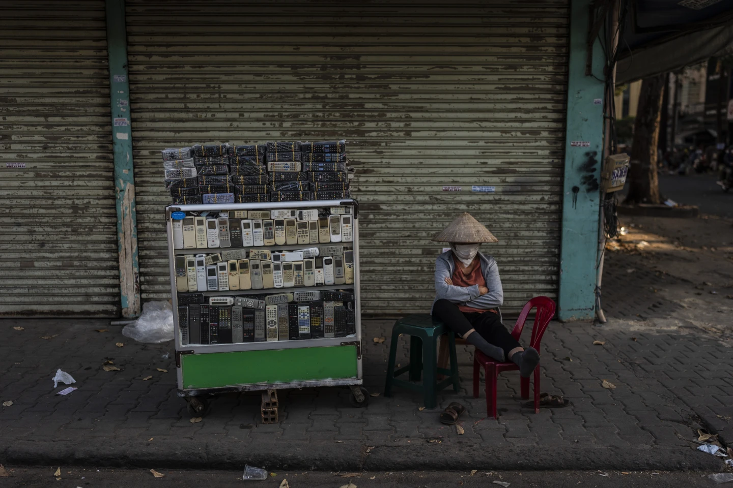 A vendor selling used remote controls for various home appliances takes a nap in Nhat Tao market, the largest informal recycling market in Ho Chi Minh City, Vietnam, Sunday, 28 January 2024. Photo: Jae C. Hong / AP Photo