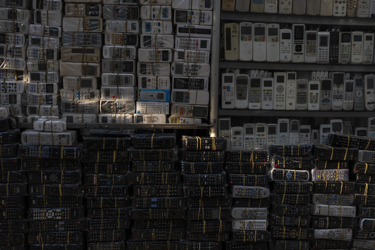 Used remote controls for various home appliances are lit by afternoon sunlight in Nhat Tao market, the largest informal recycling market in Ho Chi Minh City, Vietnam, Sunday, 28 January 2024. Photo: Jae C. Hong / AP Photo