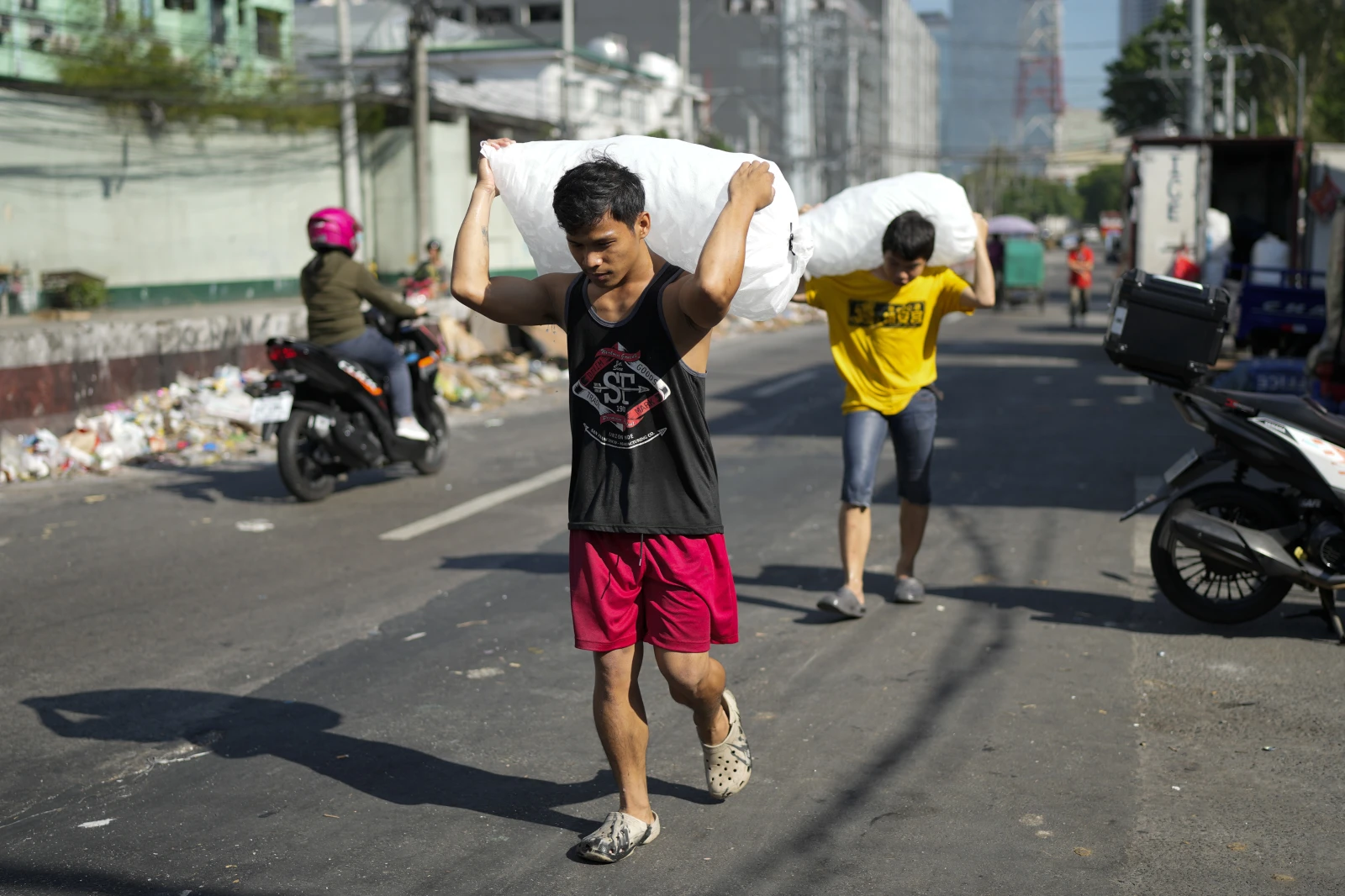 Men deliver sacks of ice cubes as demand remains high due to hot temperatures in Quezon city, Philippines on 24 April 2024. Photo: Aaron Favila / AP Photo