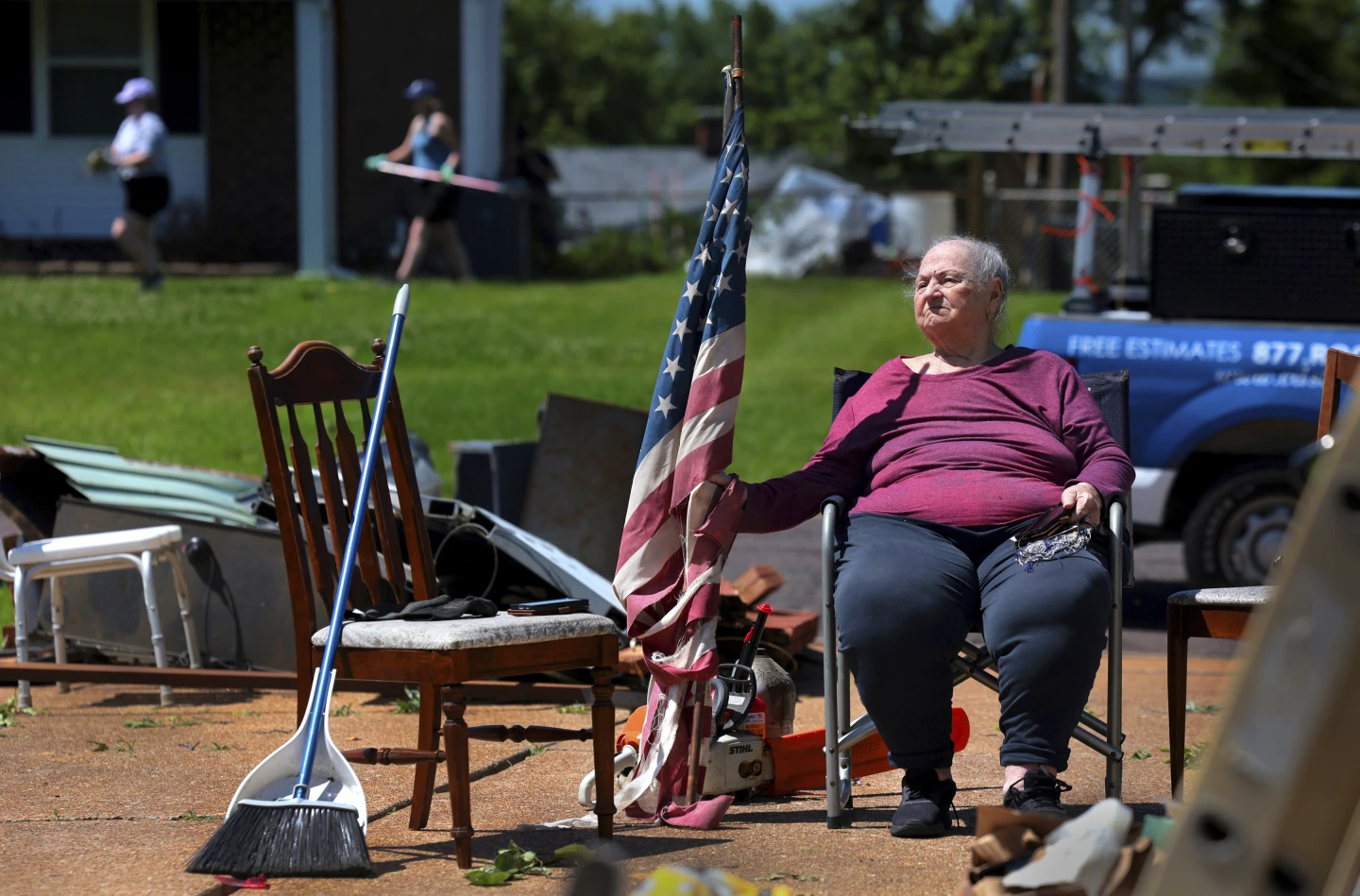 Jackie Moloney, 88, hangs on to her shredded American flag on Monday, 27 May 2024 as her family cleans up on Morningdale Place in Mehlville, Missouri following a violent storm and possible tornado that hit Sunday evening. The storm destroyed her garage and sent part of a neighbor’s roof into her backyard. Moloney’s daughter Patti Manley got her up and into an interior bathroom as the storm hit. “We heard a loud whoosh,” said Monloney, who bought her home new in 1965. “Thank God for family.” Photo: Robert Cohen / St. Louis Post-Dispatch / AP