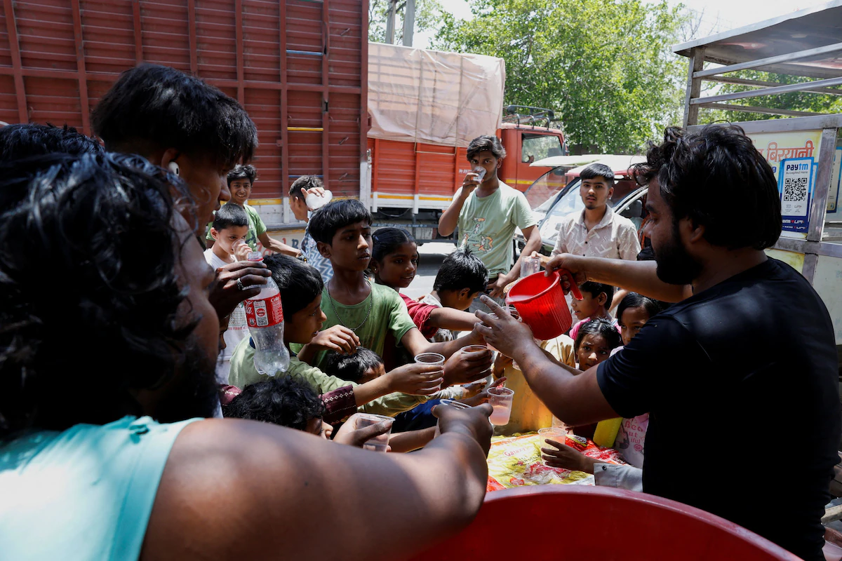 Locals offer cooling drinks to people on a hot summer day during a heat wave in Delhi on Wednesday, 29 May 2024. Photo: Reuters / Priyanshu Singh