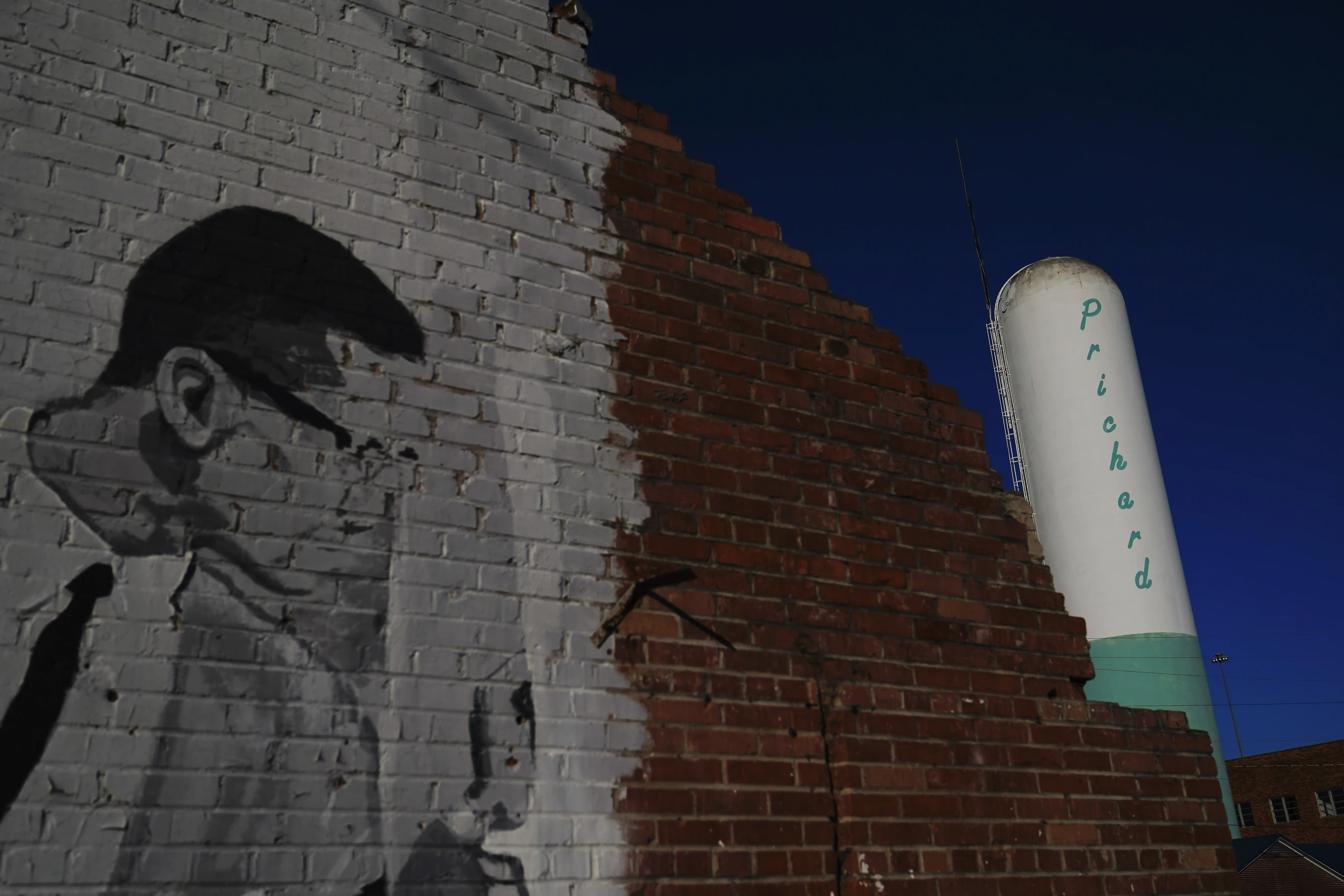 A Prichard water tower stands near downtown Prichard, Alabama, on Wednesday, 6  December 2023. For generations, the water infrastructure beneath this southern Alabama city was corroding, cracking and failing — out of sight and seemingly out of mind — as the population shrank and poverty rose. Until it became impossible to ignore. Photo: Brynn Anderson / AP Photo