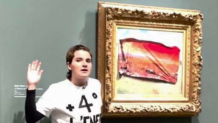 A member of Riposte Alimentaire (Food Response) posing after covering Claude Monet’s painting Les Coquelicots at the Musée d'Orsay in Paris, France with a sticker. In the video she said of the poster covering Monet’s art that “this nightmarish image awaits us if no alternative is put in place”. Photo: Roberta Fumagalli / AFP
