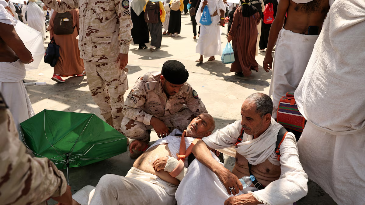 A man affected by the scorching heat on Sunday, 16 June 2024 is helped by a member of the Saudi security forces during the Hajj pilgrimage to Saudi Arabia’s holy city of Mecca. Photo: Fadel Senna / AFP / Getty Images