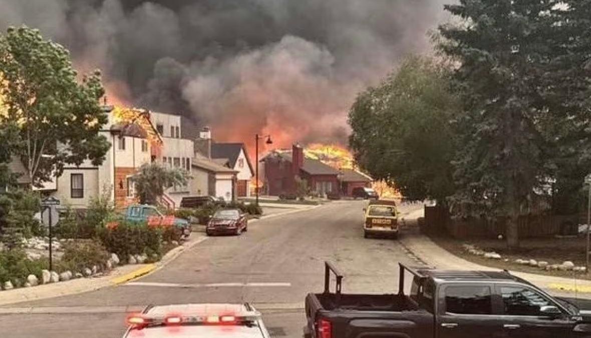 Wildfires that threatened Jasper for days reached the Alberta mountainside town Wednesday evening, 24 July 2024. Shown here are properties are engulfed in flames at the corner of Cabin Creek Drive and Patricia Street. Photo: CBC