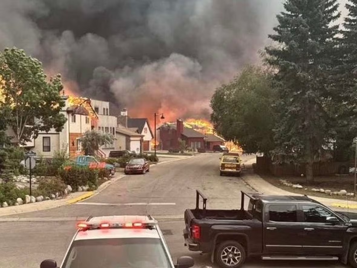 Wildfires that threatened Jasper for days reached the Alberta mountainside town Wednesday evening, 24 July 2024. Shown here are properties are engulfed in flames at the corner of Cabin Creek Drive and Patricia Street. Photo: CBC