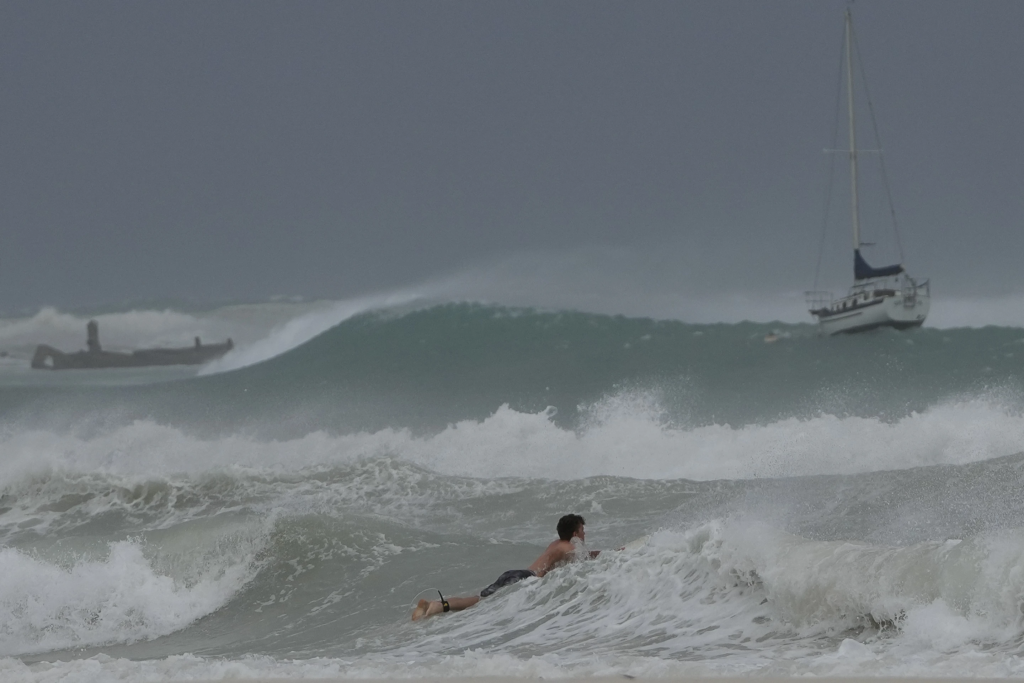 A surfer braves the waves in Carlisle Bay as Hurricane Beryl passes through Bridgetown, Barbados, 1 July 2024. Photo: Ricardo Mazalan / AP Photo