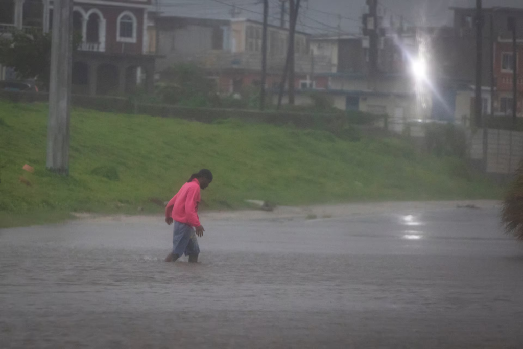 A man walks in a flooded street as Hurricane Beryl hits the southern coast of the island, in Kingston, Jamaica, 3 July 2024. Photo: Marco Bello / REUTERS