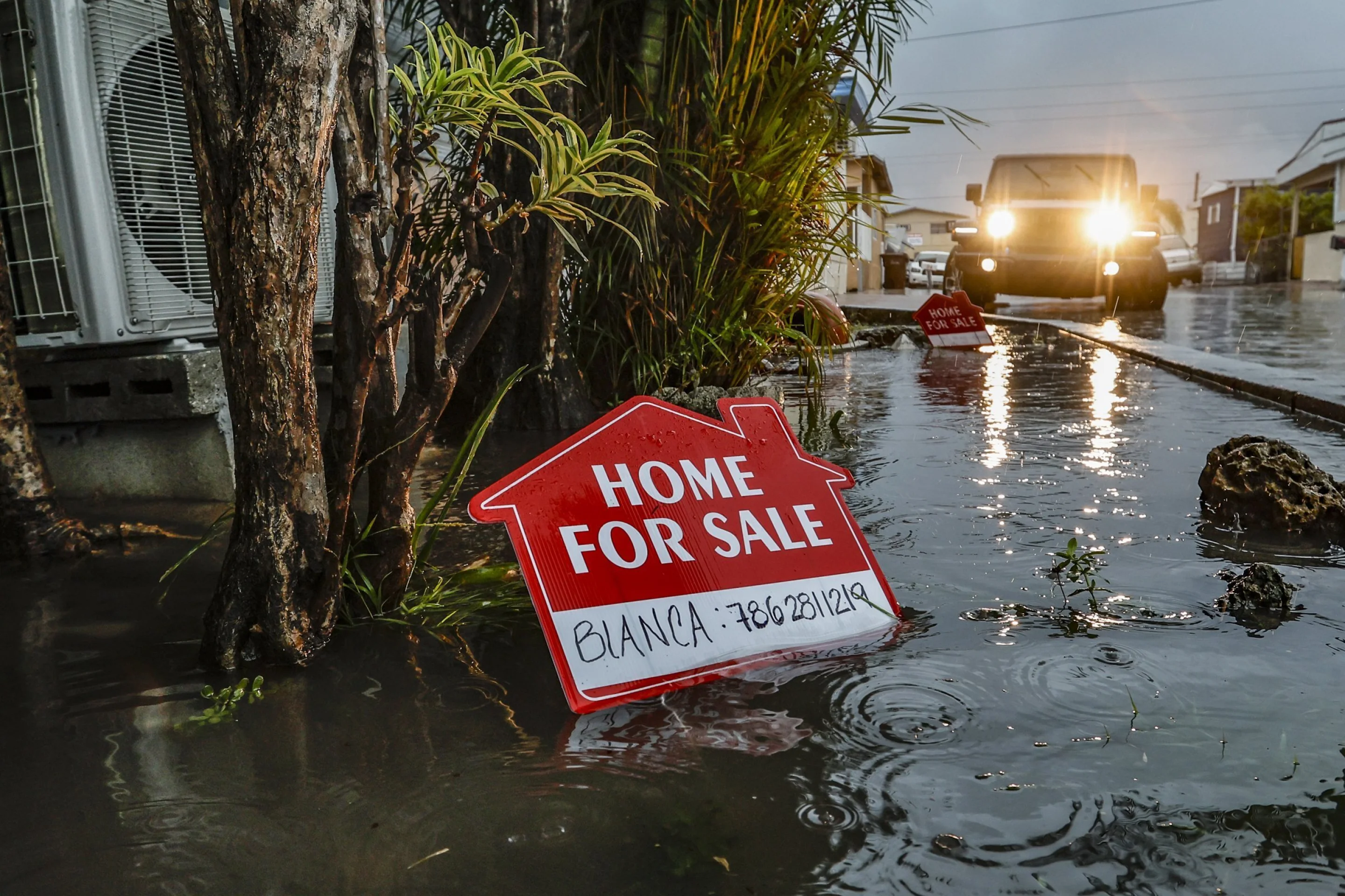 A “for sale” sign is posted in a flooded area of Holiday Acres Mobile Home Park in Hialeah, Florida. on Wednesday, 12 June 2024. Photo: Al Diaz / Miami Herald / AP