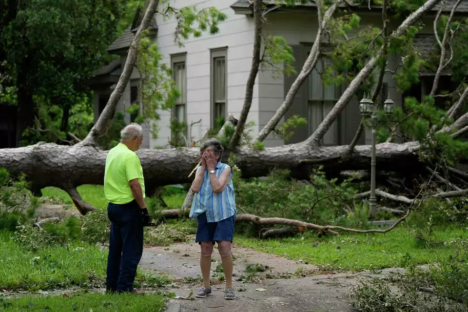 Jackie Jecmenek, right, talks with city worker Bobby Head as she stands in front of her neighbor’s home after HUrricane Beryl passed, 8 July 2024, in Bay City, Texas. Photo: Eric Gay / AP