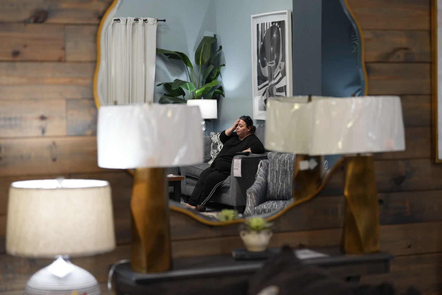 Houston resident Adriana Guerrero is reflected in a mirror as she spend time at Gallery Furniture, which is being used as a temporary shelter, to cool off and and have a meal, Tuesday, 9 July 2024, in Houston. The effects of Hurricane Beryl left most in the area without power. Photo: Eric Gay / AP Photo